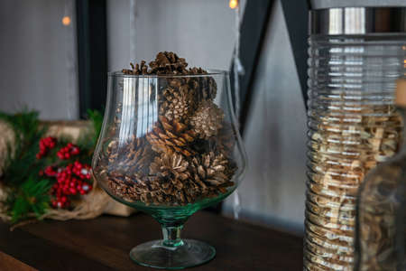 Large glass vase with pine cones. Natural Decorating for Christmas. New year holiday, celebration conceptの写真素材