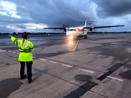 Ground flight coordinator giving the OK to take off a turboprop aircraft in Seville Airport, Spainのeditorial素材