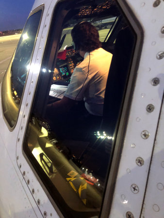 Airbus A320 commercial airplane pilot inside the cockpit seen from the outside through a side windowのeditorial素材