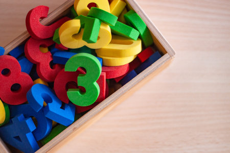wooden box filled with colorful numbers, used for children learning