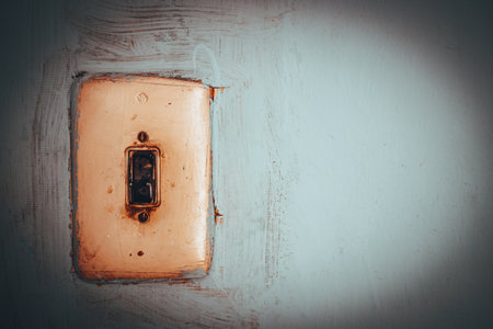 Vintage Light Switch on a Textured Wall Surfaceの写真素材