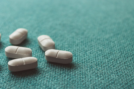 Scattered Capsules on Textured Blue Backgroundの写真素材