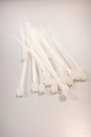 White Plastic Cable Ties Arranged on a Smooth Surface with Soft Light and Shallow Depth of Field