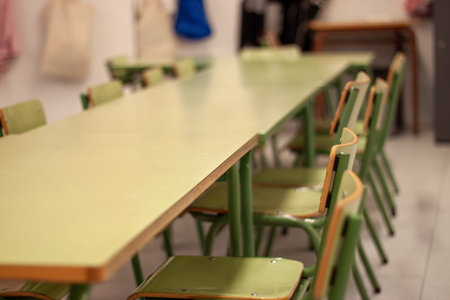 Empty classroom with green chairs and long table