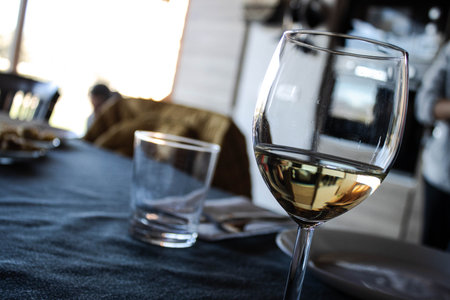 White wine glass on a dining table with soft daylightの写真素材