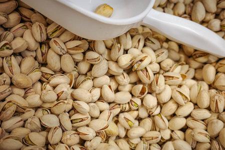 Scoop of pistachios in bulk healthy nuts background