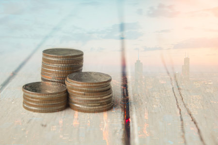 Double exposure of coin stack on wood table and light , concept save and financial