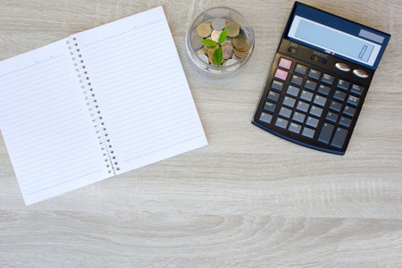 Calculator with coins and notebook on wooden table, Concept Business and financialの写真素材