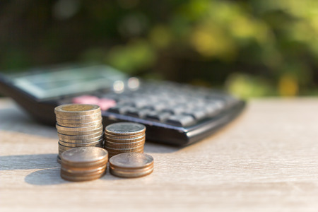 Step of coins stacks on table with calculator and bokeh background , money, Concept saving and investmentの写真素材
