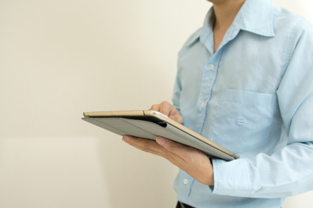 Business and finance or trading concept : Businessman holding digital tablet at office, Businesswoman calculate about cost, Finance managers task.の写真素材