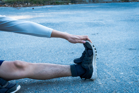 Exercise fitness training concept : Healthy young man warming up at the park outdoor. She is...