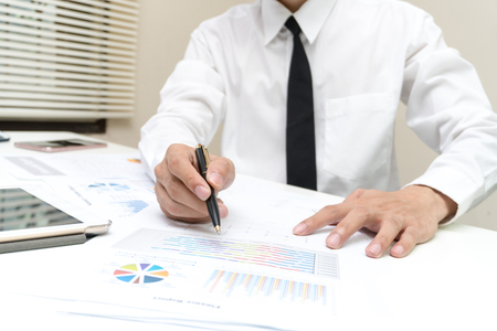 Business and finance concept : Businessman check about cost and doing finance graph report at office, Finance managers task,Businessman recheck new plan financial graph data.の写真素材