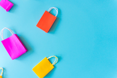 Minimal shoping online concept, Colorful paper shopping bag go down from floating pink background for copy space. Customer can buy everthing form home and the messenger will deliver.の写真素材