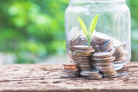 Investment and financial saving falling concept, Glasses and coins on table with green backgroundの写真素材