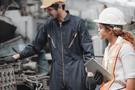 Engineer and staff or Industrial worker talking production line machine and setting it for work in...