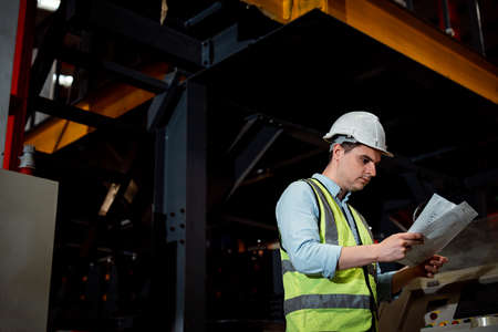 Maintenance engineers men and women inspect relay protection system with checklist document . They work a heavy industry manufacturing factory.の写真素材