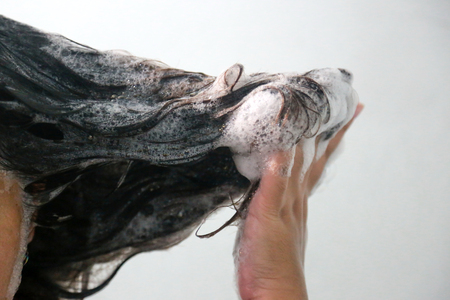 Women are washing hair with shampoo in the bathroom.の写真素材