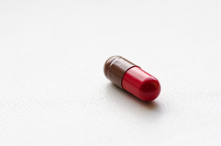 Medicine capsule / Red-brown capsules on a light backgroundの写真素材