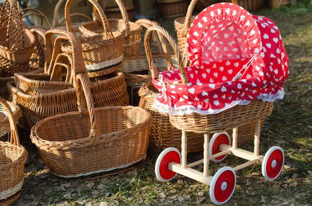 straw baskets and wooden stroller with a red topの写真素材