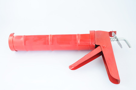 Orange silicone glue gun on white backgroundの写真素材