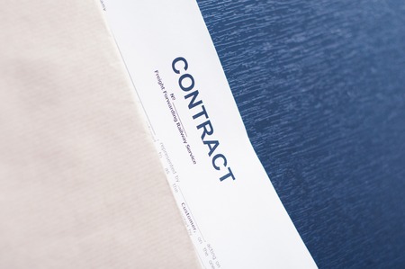 Contract in a brown envelope on a black tableの写真素材