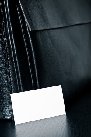 white card for writing with black leather bag on the table.の写真素材