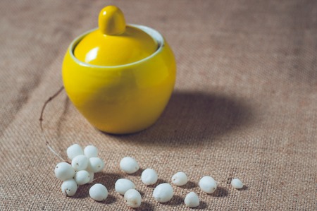 Yellow sugar bowl on a table with white balls.の写真素材