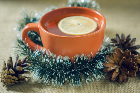 Christmas tea with lemon on a background garlands.
