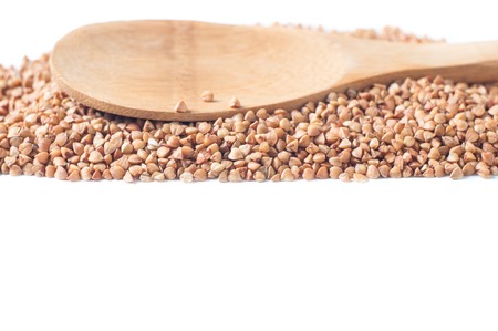 buckwheat isolated with a wooden spoon on white background.の写真素材
