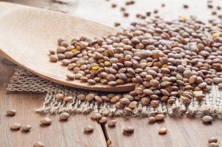 Organic lentils with wooden false on burlap background.の写真素材