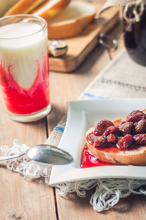 Strawberry Jam, bread and milk on the table background.の写真素材