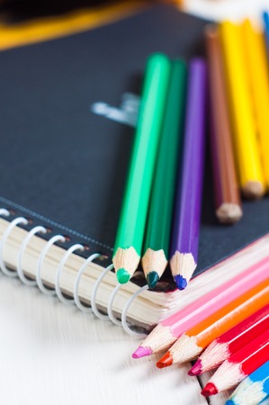sketchbook and colorful pencils on the tableの写真素材