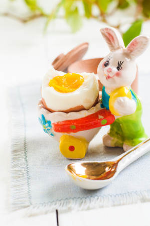 Easter rabbit and egg on white wooden table background.の写真素材