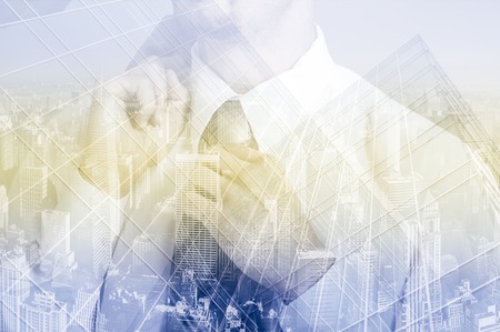 Double exposure concept with thinking businessman adjusting his tie.の写真素材