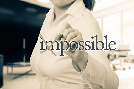 Beautiful woman converting the word impossible to possible.の写真素材