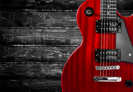 Part of the red electric guitar on wooden background. A place for writing of the textの写真素材