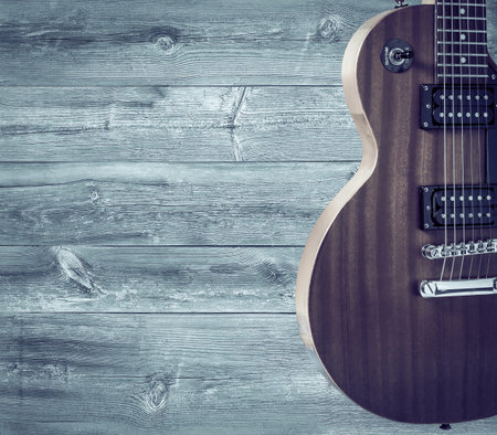 Part of the orange electric guitar on wooden background. A place for writing of the textの写真素材