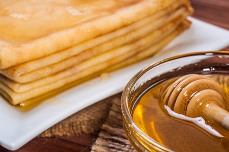 Fresh honey with a Stack of blinis or crepes.の写真素材