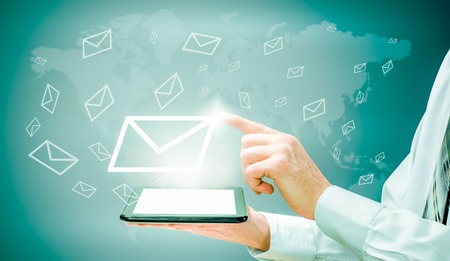 The concept of email marketing. Businessman makes sending emails from your tablet.の写真素材