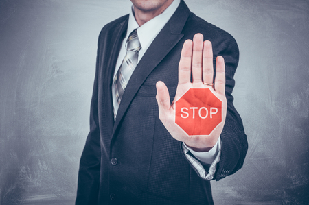 Businessman shows stop sign painted on the hand.の写真素材