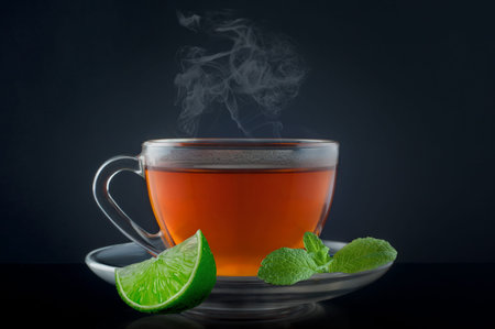 Cup tea with mint and lime on a black background.の写真素材