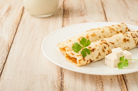 Food photography. Thin pancakes with filling and slices of cheese with herbs.の写真素材