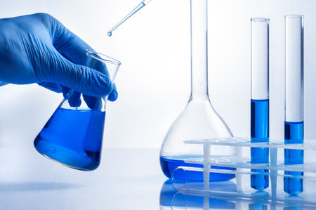 Laboratory beaker in analyst's hand in plastic glove