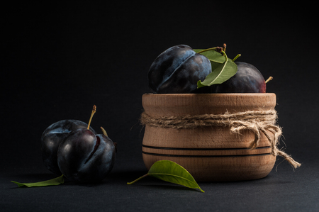 Garden plums in bowl on stone table. View with copy space.の写真素材