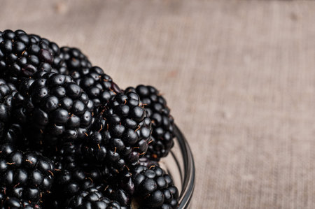 Fresh Ripe Juicy Blackberries in a plate on black background.の写真素材