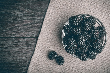 Fresh Ripe Juicy Blackberries in a plate on black background.の写真素材