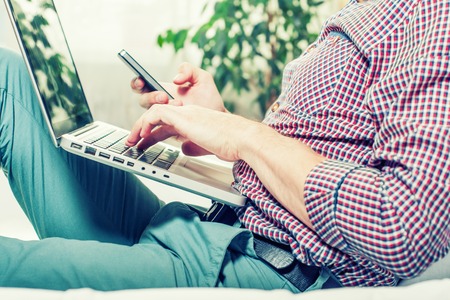 elegant business multitasking multimedia man using devices at home.の写真素材