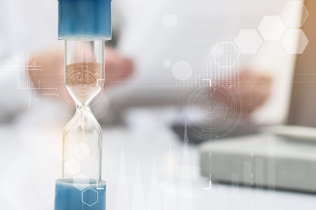 Hourglass. Businessman working in the office in the background. Concept time is money.