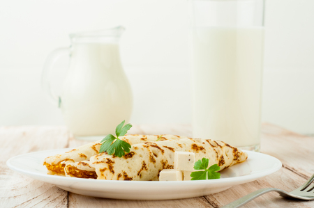 Food photography. Thin pancakes with filling and slices of cheese with herbsの写真素材