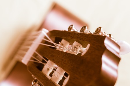 Part of an acoustic guitar on a grey background.の写真素材
